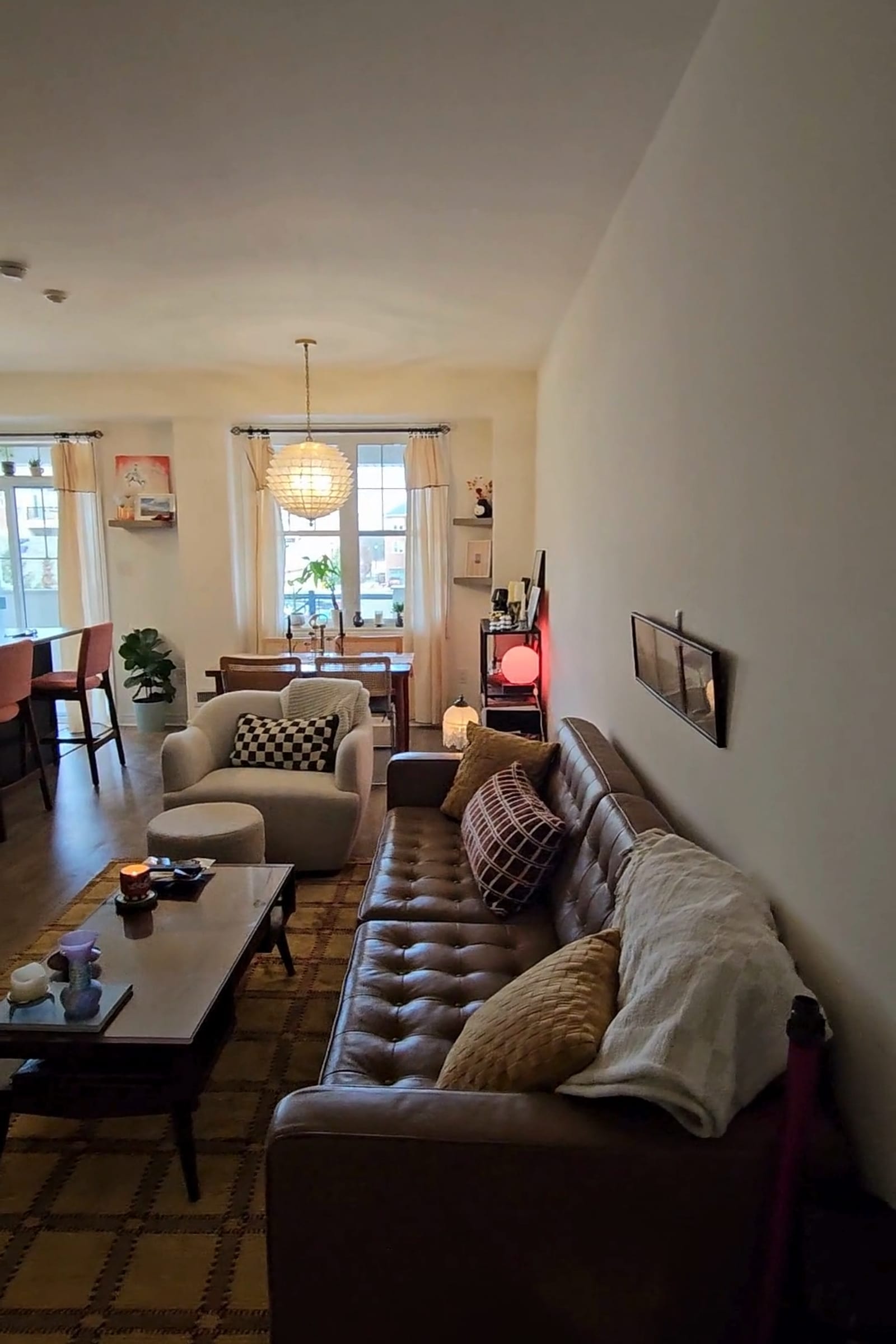 Inside an apartment on a phone walkthrough — the living-room sofa, coffee table and dining area a moving quote has to account for.